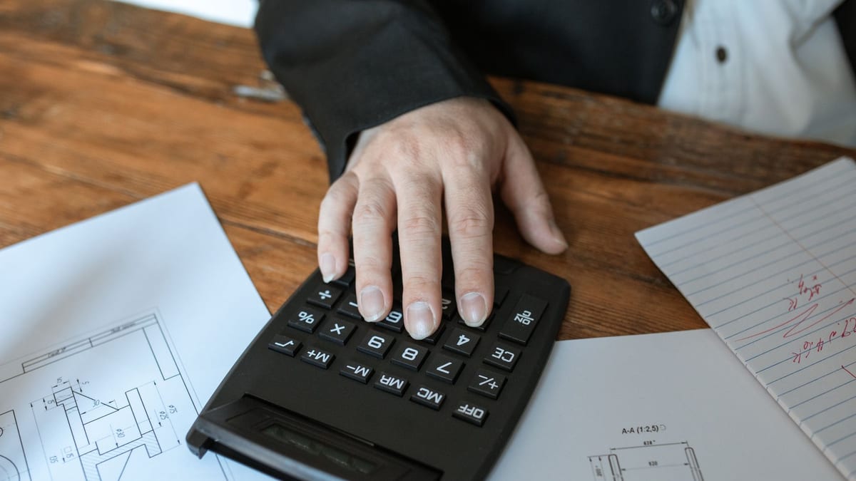 A calculator and paperwork on a desk, working out how to pay for plastic surgery