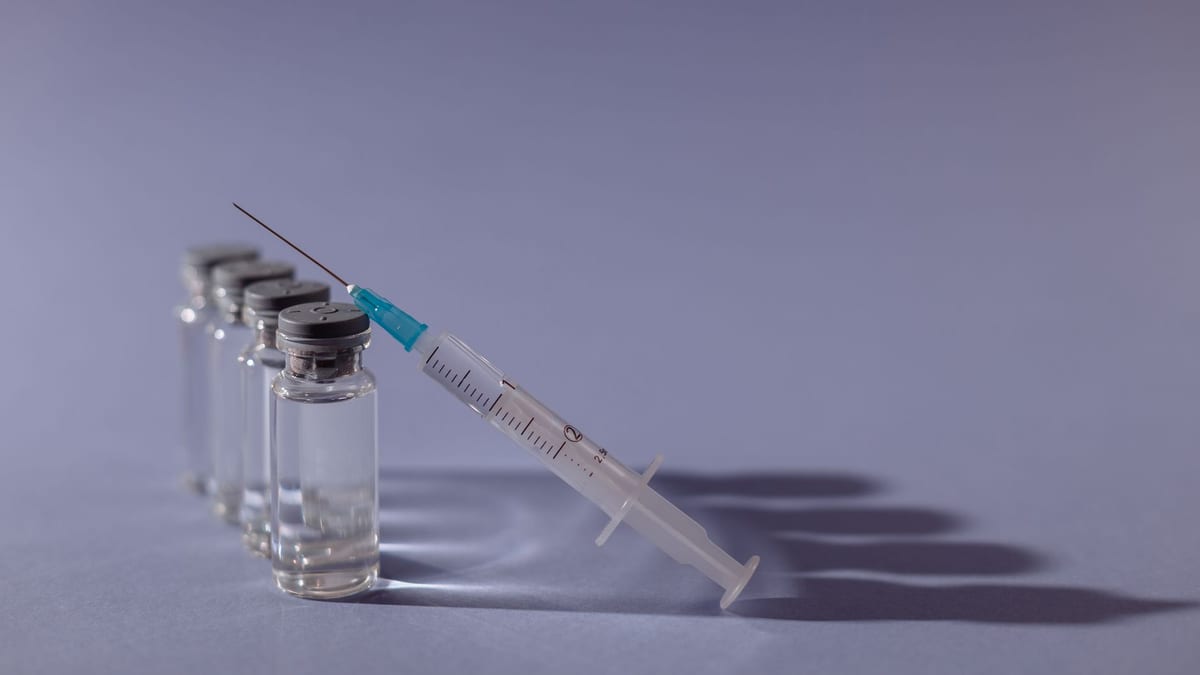 Vials and a syringe laid out on a clinic tray