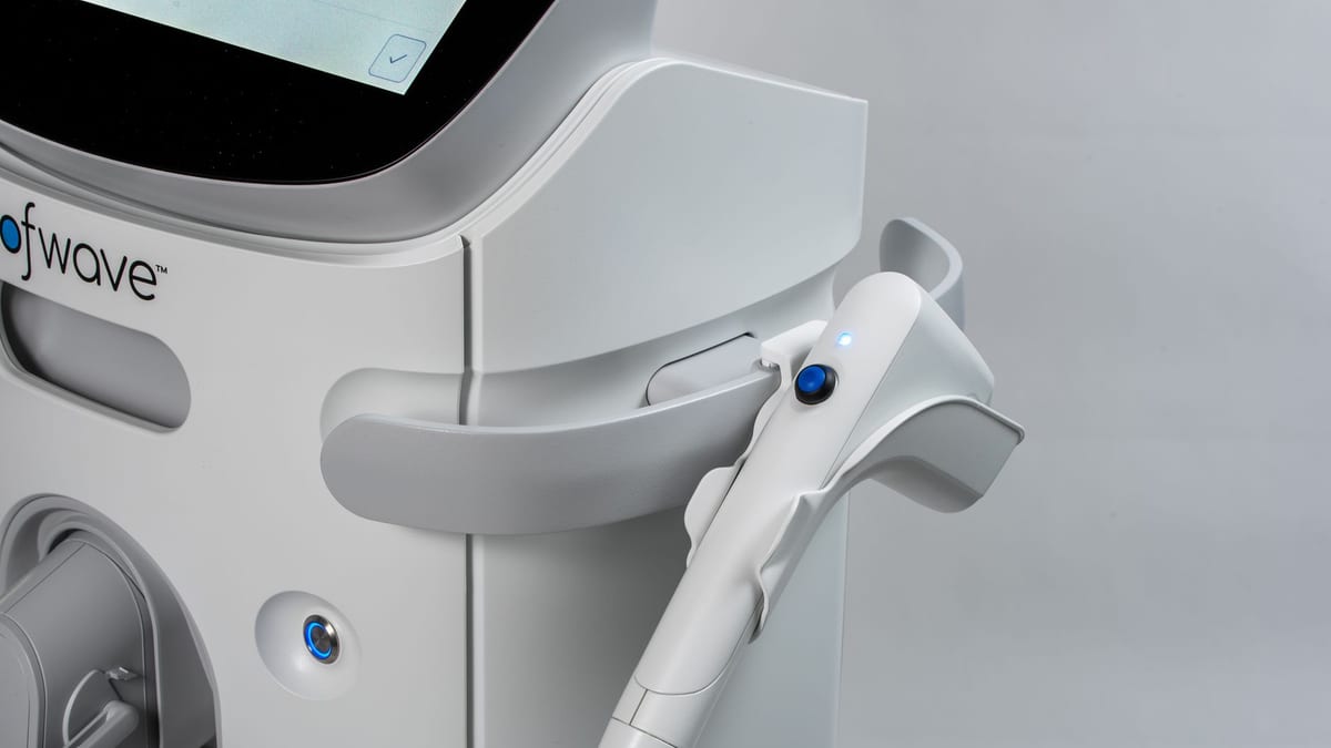 An aesthetic device beside a treatment bed in a med spa