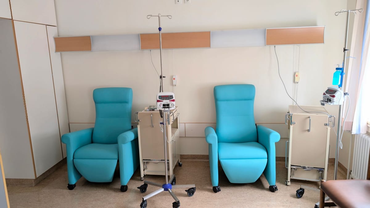 An IV drip bag hung beside a clinic treatment chair