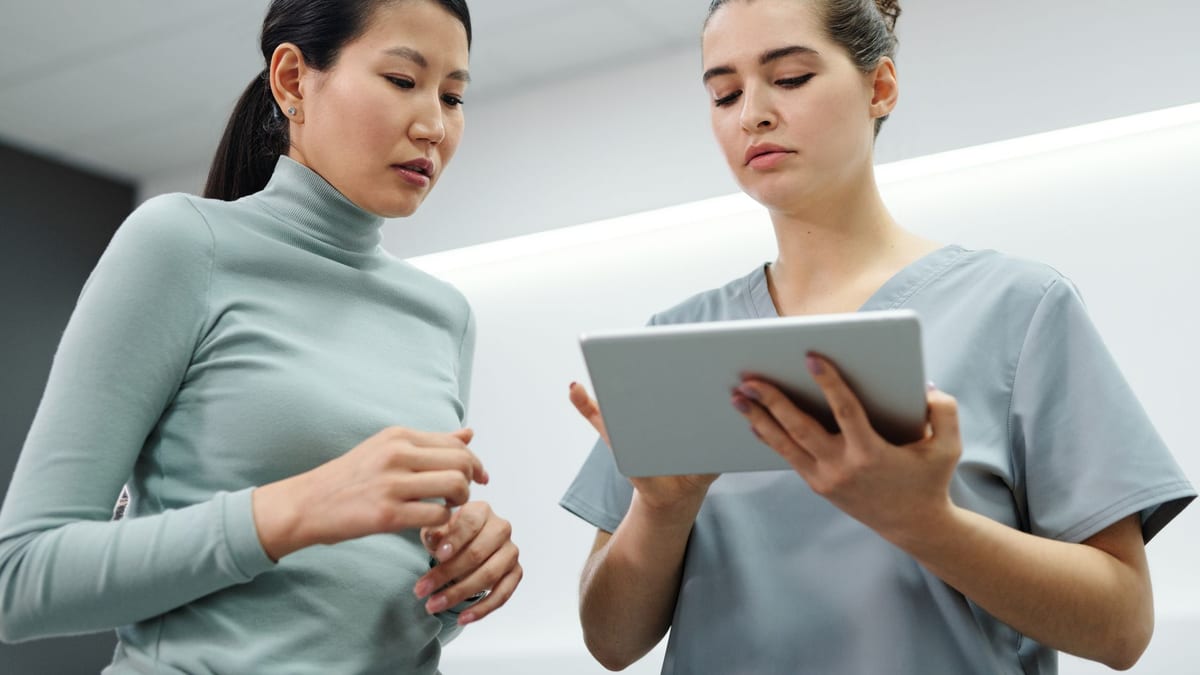 A surgeon reviewing options with a patient on a tablet