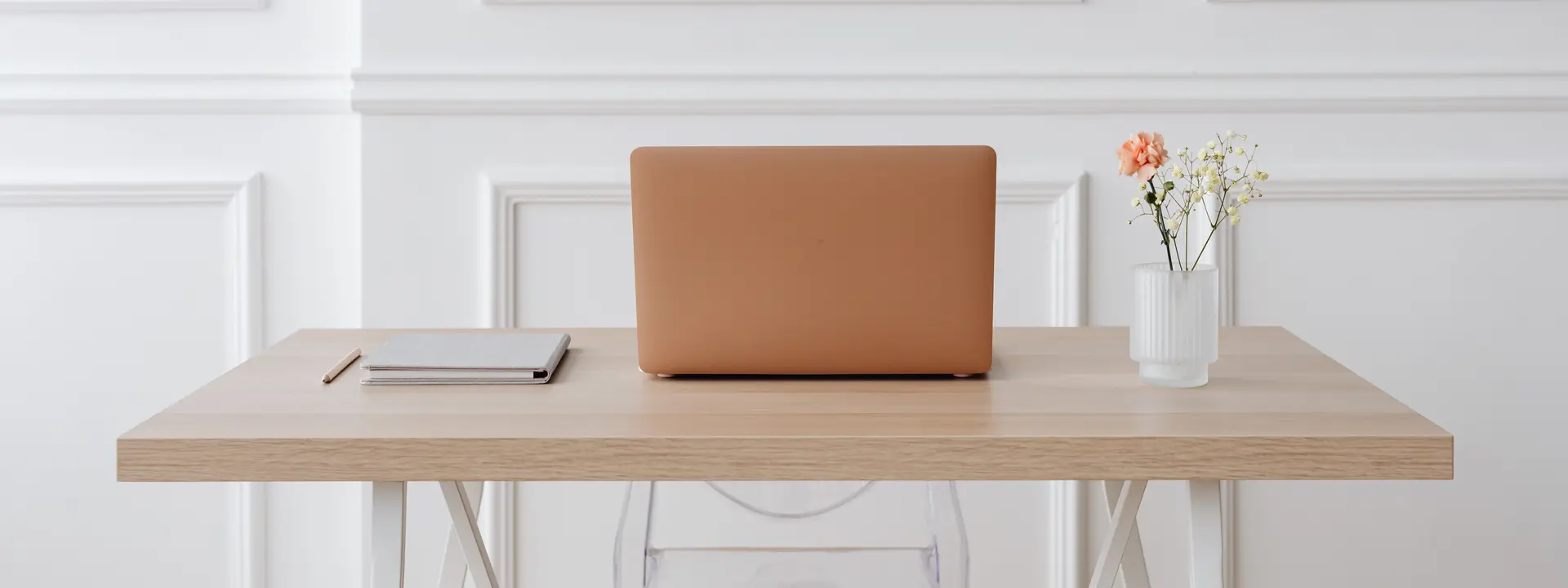 A calm consultation desk with a laptop and a vase of flowers